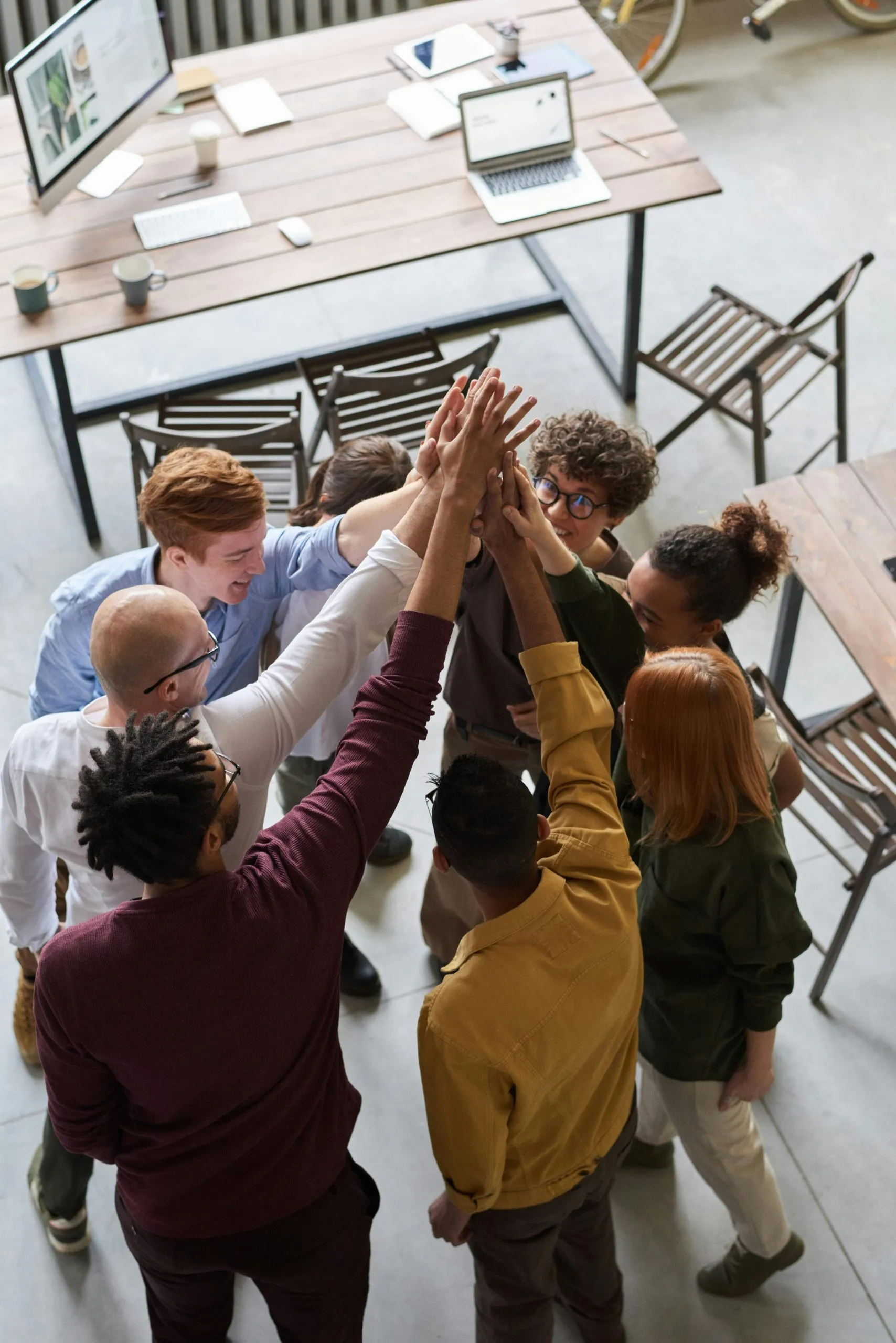 Team huddle with hands together in an office setting